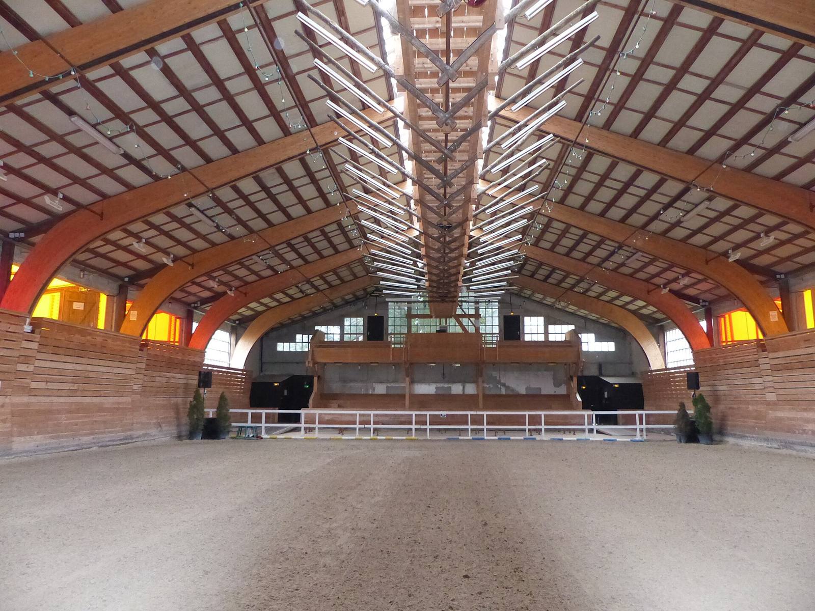 Picadero cubierto con suelo de arena y vigas de madera